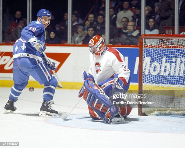 Joe Sakic of the Quebec Nordiques skates against goaltender Patrick Roy of the Montreal Canadiens in the early 1990's at the Montreal Forum in...