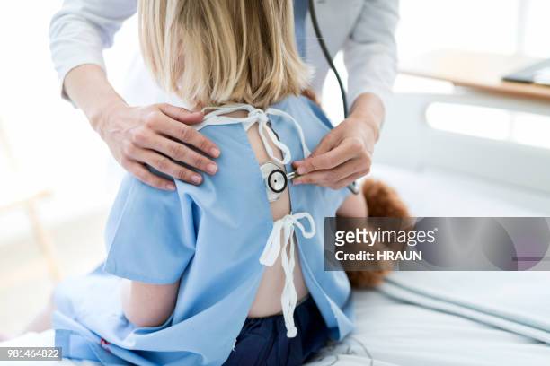 doctor examining girl with stethoscope in hospital - estetoscopio imagens e fotografias de stock