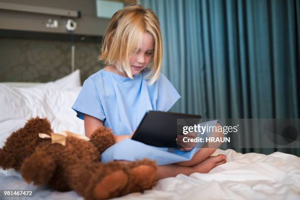 sick girl using digital tablet on hospital bed - childrens hospital stock pictures, royalty-free photos & images