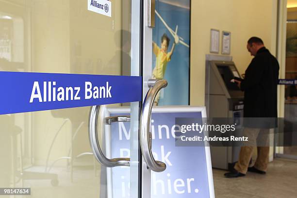 Customer uses an ATM at an Allianz bank on March 30, 2010 in Berlin, Germany. Allianz focused on their core market Germany under the brand name...