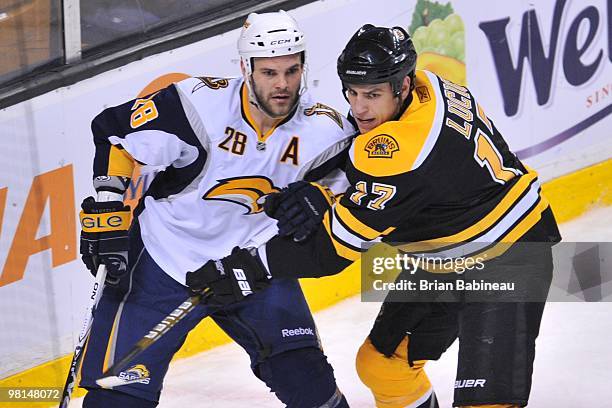 Milan Lucic of the Boston Bruins checks Paul Gaustad of the Buffalo Sabres at the TD Garden on March 29, 2010 in Boston, Massachusetts.