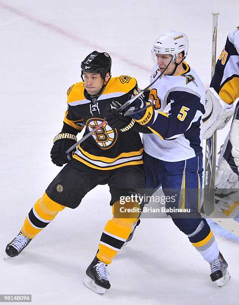 Marco Sturm of the Boston Bruins checks Toni Lydman of the Buffalo Sabres at the TD Garden on March 29, 2010 in Boston, Massachusetts.