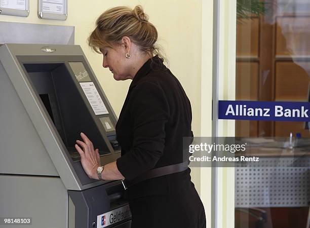 Customer uses an ATM at an Allianz bank on March 30, 2010 in Berlin, Germany. Allianz focused on their core market Germany under the brand name...