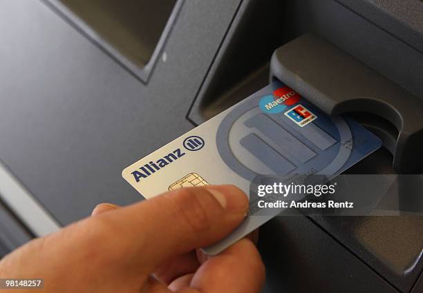 In this photo illustration a customer uses an ATM at an Allianz bank on March 30, 2010 in Berlin, Germany. Allianz focused on their core market...