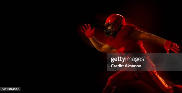 american football-spieler auf einem dunkelroten hintergrund - phosphorescence stock-fotos und bilder