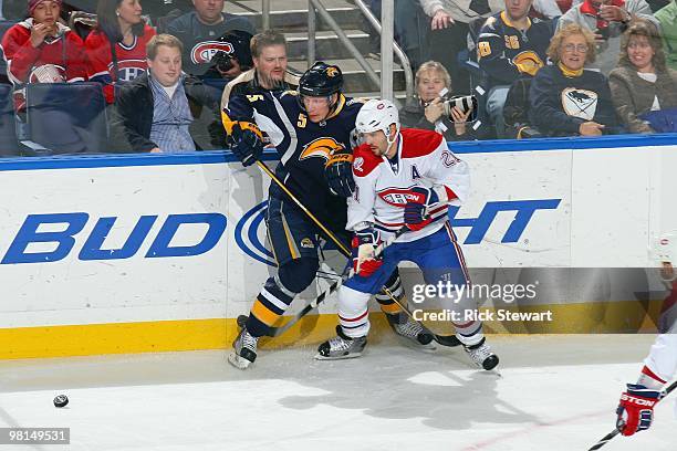 Brian Gionta of the Montreal Canadiens moves for the puck against Toni Lydman of the Buffalo Sabres at HSBC Arena on March 24, 2010 in Buffalo, New...