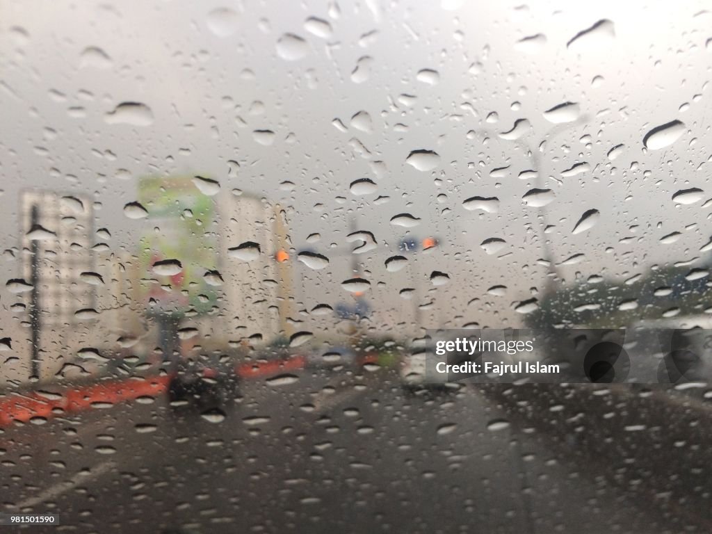 Raindrops at windshield on the city road