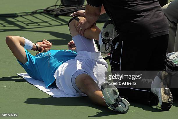 Mardy Fish of the United States gets worked on by a trainer while playing against Mikhail Youzhny of Russia during day eight of the 2010 Sony...