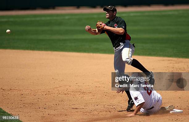 Hardy of the Minnesota Twins is caught in a double play by shortstop Bobby Crosby of the Pittsburgh Pirates on March 30, 2010 at Hammond Stadium in...