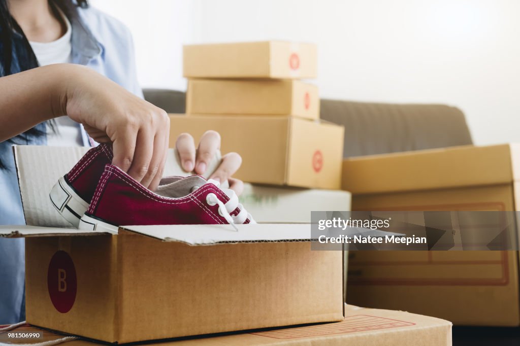 Happy young businessman owner packing shoes to cardboard box, Young Owner Woman Start up for Business Online. People with online shopping SME entrepreneur or freelance working concept.