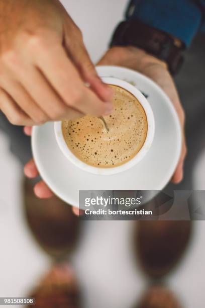 close-up of hand holding coffee cup - bortes fotografías e imágenes de stock