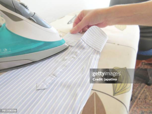 homework. ironing of clothes on ironing board - pantalón decorado fotografías e imágenes de stock