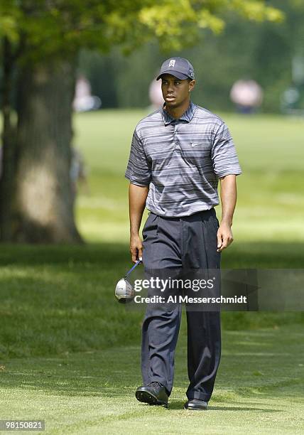 Tiger Woods carries his driver up the fairway after an errant tee shot on the ninth hole in the first round of the Cialis Western Open July 1, 2004...