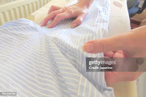 homework. ironing of clothes on ironing board - pantalón decorado fotografías e imágenes de stock