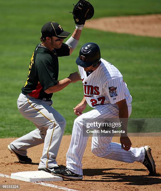 Hardy of the Minnesota Twins gets back to first base before the tag of first baseman Steve Pearce of the Pittsburgh Pirates on March 30, 2010 at...