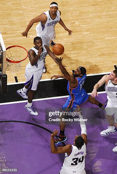 James Harden of the Oklahoma City Thunder shoots a layup against Tyreke Evans, Jason Thompson and Spencer Hawes of the Sacramento Kings during the...