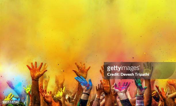 hands painted with different colors raised up on holi festival, washington dc, usa - religion stockfoto's en -beelden
