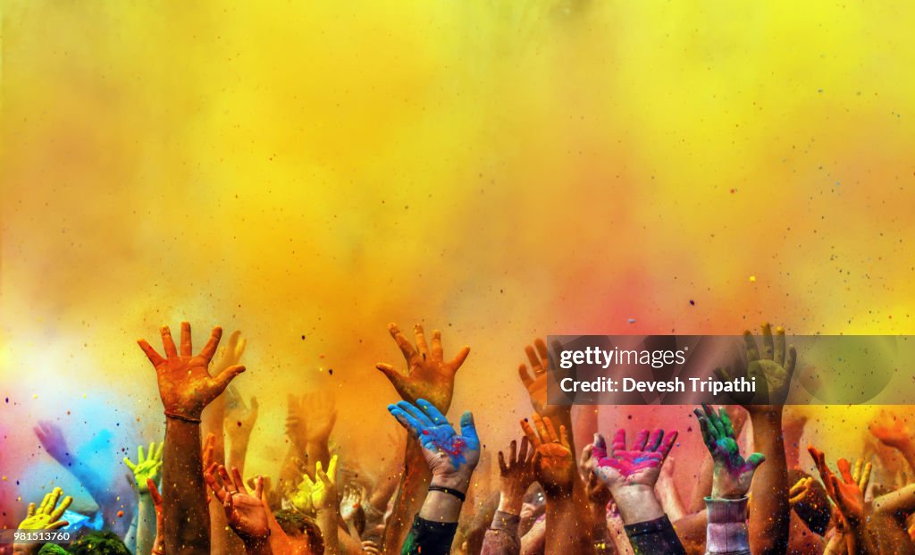 Hands painted with different colors raised up on Holi festival, Washington DC, USA