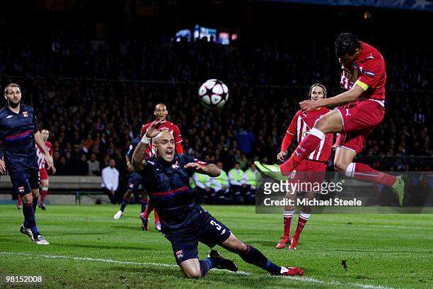 Marouane Chamakh of Bordeaux scores his sides first goal as Cris of Lyon falls to the ground during the Lyon v Bordeaux UEFA Champions League...