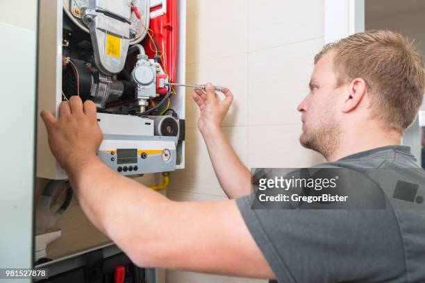 technician repairing gas furnace - home furnace stock pictures, royalty-free photos & images