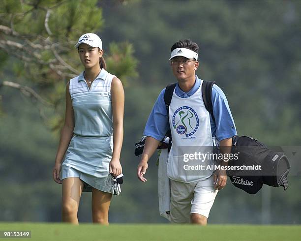 Michelle Wie, a 13-year-old amateur from Honolulu, walks up the 5th fairway with her father, B. J. Wie, at the LPGA Jamie Farr Kroger Classic August...