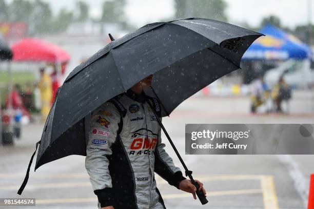 Justin Haley, driver of the Fraternal Order Of Eagles Chevrolet, walks through the garage as rain falls prior to practice for the NASCAR Camping...