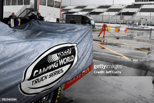 Truck sits in the garage as crew members clear the track after a rain storm prior to the start of practice for the NASCAR Camping World Truck Series...