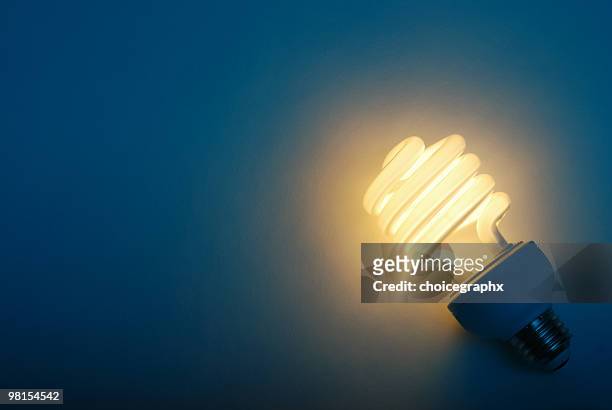 savings with efficient compact fluorescent light bulb - energy efficient lightbulb bildbanksfoton och bilder