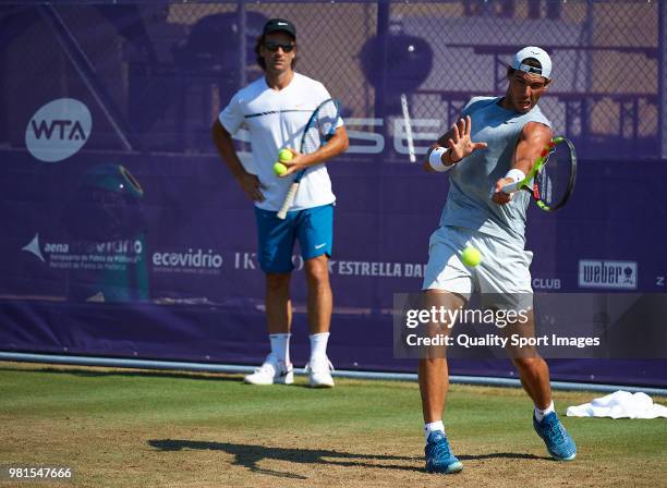 Rafael Nadal of Spain hits a shot in training as his coach Carlos Moya looks on during day five of the Mallorca Open at Country Club Santa Ponsa on...