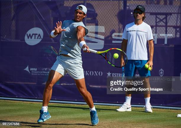 Rafael Nadal of Spain hits a shot in training as his coach Carlos Moya looks on during day five of the Mallorca Open at Country Club Santa Ponsa on...