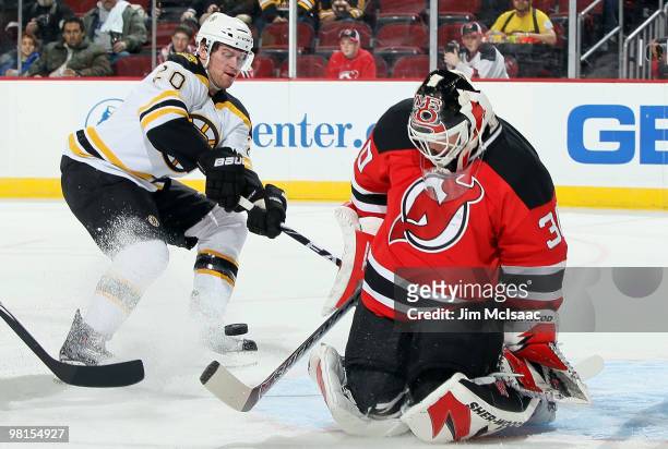 Martin Brodeur of the New Jersey Devils makes a first period save as Daniel Paille of the Boston Bruins looks for a rebound at the Prudential Center...