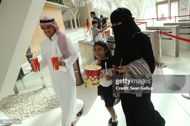 Saudi family carrying Cokes and popcorn arrives to watch "The Incredibles 2" at the newly-opened AMC Cinema in the King Abdullah Financial District...