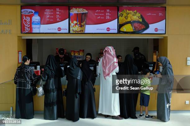 Movie goers buy Cokes and popcorn before watching "The Incredibles 2" at the newly-opened AMC Cinema in the King Abdullah Financial District on June...