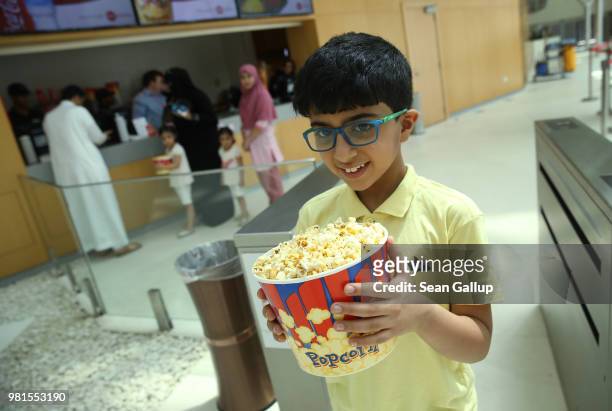 Manzur clutches a bucket of popcorn as he and his family arrive on their first outing ever to a cinema in Saudi Arabia to watch "The Incredibles 2"...