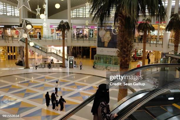 Women wearing the traditional niqab and abaya stroll through a shopping mall on June 20, 2018 in Riyadh, Saudi Arabia. The Saudi government, under...