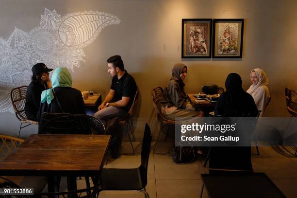 Guests chat at Medd Cafe and Roastery, a popular hangout where young Saudi men and women mix together freely, on June 21, 2018 in Jeddah, Saudi...