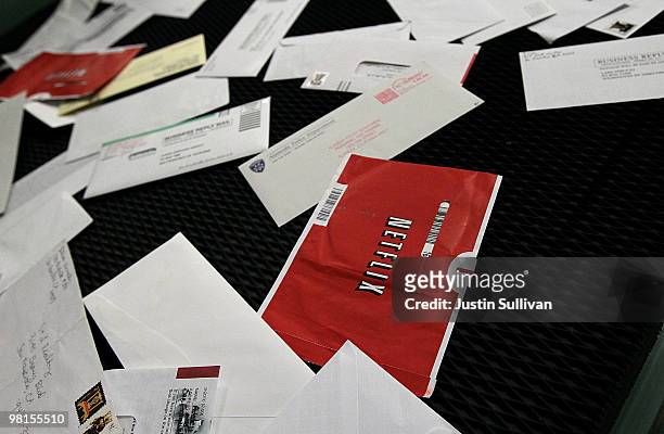 Red Netflix envelopes move on a conveyor belt with other mail at the U.S. Post Office sort center March 30, 2010 in San Francisco, California. If the...