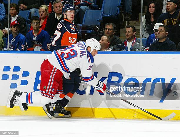 Michal Rozsival of the New York Rangers and Blake Comeau of the New York Islanders pursue the puck along the boards on March 30, 2010 at Nassau...