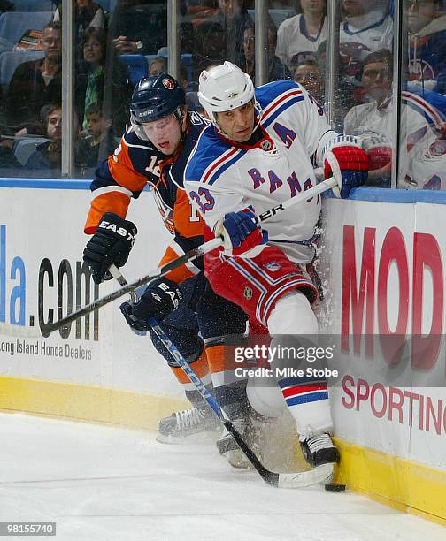 Michal Rozsival of the New York Rangers and Josh Bailey of the New York Islanders battle for the puck along the boards on March 30, 2010 at Nassau...