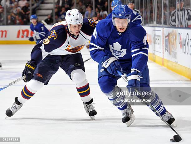 Nikolai Kulemin of the Toronto Maple Leafs skates the puck away from Marty Reasoner of the Atlanta Thrashers March 30, 2010 at the Air Canada Centre...