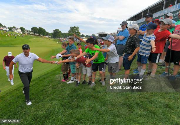 Jason Day of Australia gives away his glove to a fan on the 18th hole during the second round of the Travelers Championship at TPC River Highlands on...