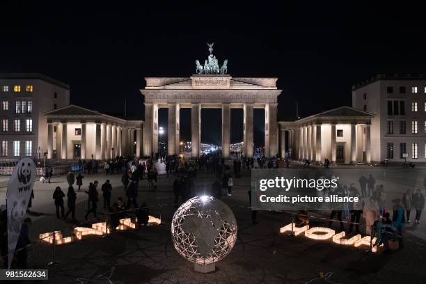 March 2018, Germany, Berlin: A light ball and the words 'Earth Hour' can be seen in front of the Brandenburg Gate. This was arranged within an action...