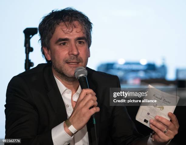 March 2018, Germany, Berlin: Journalist Deniz Yücel shows the book 'The Little Prince' during the event 'On Freedom' at Festsaal Kreuzberg. It is the...