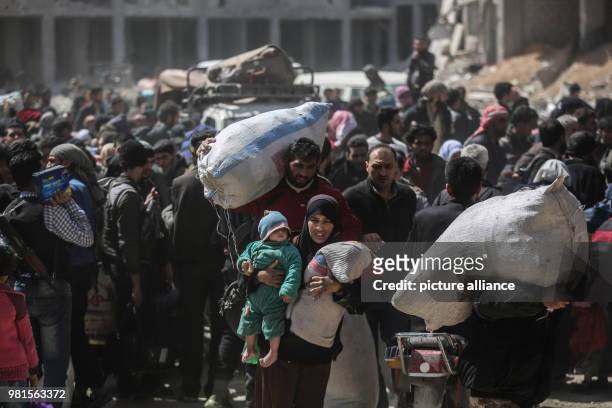 Dpatop - Syrian carry belongings while being evacuated from Zamlka in Syria's eastern Al-Ghouta province outside Damascus, Syria, 25 March 2018....