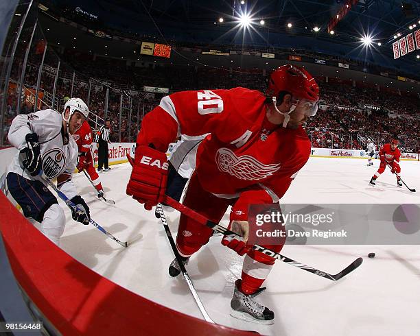 Henrik Zetterberg of the Detroit Red Wings tries to keep the puck away from Fernando Pisani of the Edmonton Oilers during an NHL game at Joe Louis...