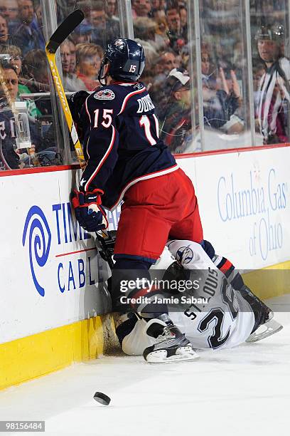 Derek Dorsett of the Columbus Blue Jackets finishes a check on Martin St. Louis of the Tampa Bay Lightning during the second period on March 30, 2010...