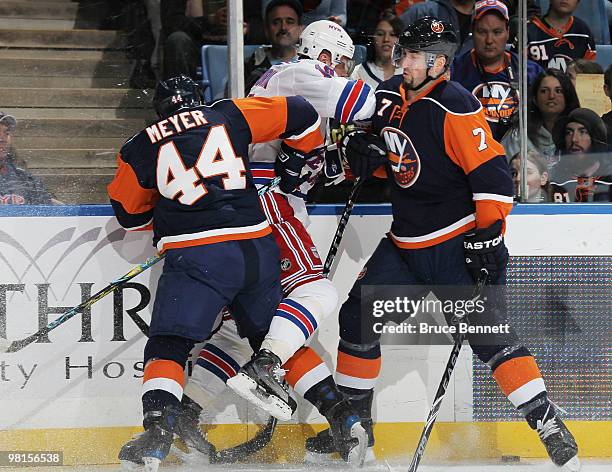 Freddy Meyer and Trent Hunter of the New York Islanders combine to hit Marian Gaborik of the New York Rangers at the Nassau Coliseum on March 30,...