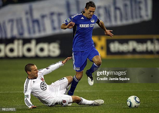 Davy Arnaud of the Kansas City Wizards leaps over a sliding Kurt Morsink of D.C United during the game on March 27, 2010 at Community America Park in...