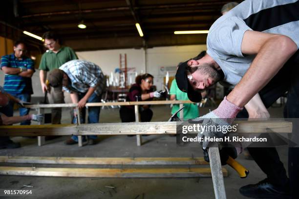 Student Eddie Haun, right, hammers in nails as he and other students learn how to make concrete forms during the Construction Careers Now! program at...