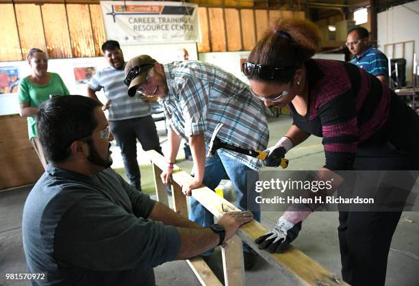 Instructor Moses Alvarez, left, teaches the finer points of building concrete forms to students Rafelina Garibay, right, and Andrew Parker middle,...